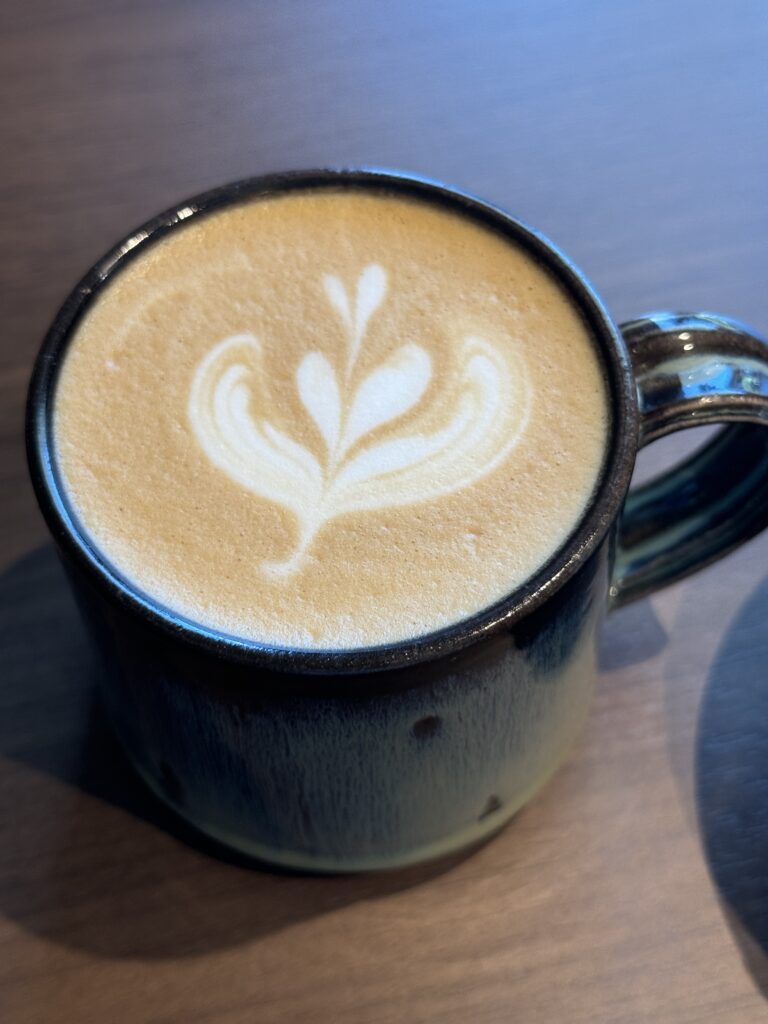 葉っぱとハートの模様にラテアートされたカフェラテ