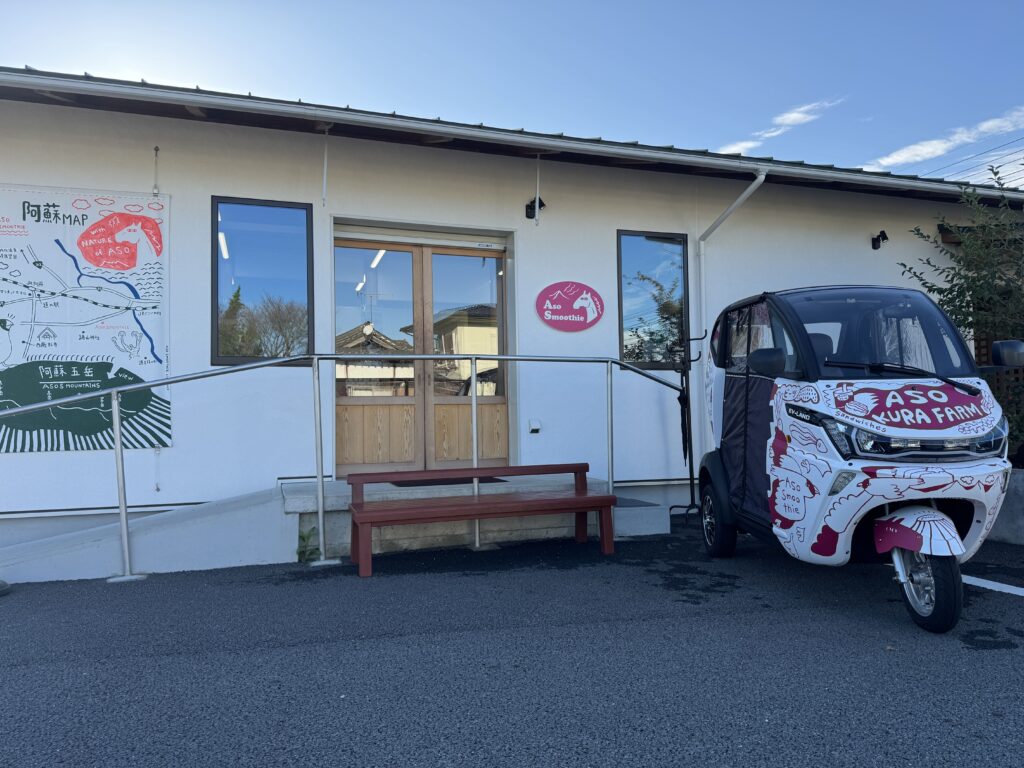 aso smoothieの外観。白い壁にピンク色が鮮やかなお店