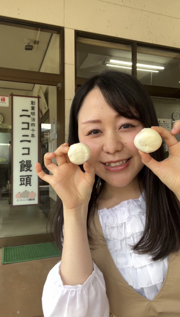 ニコニコ饅頭を持つ筆者