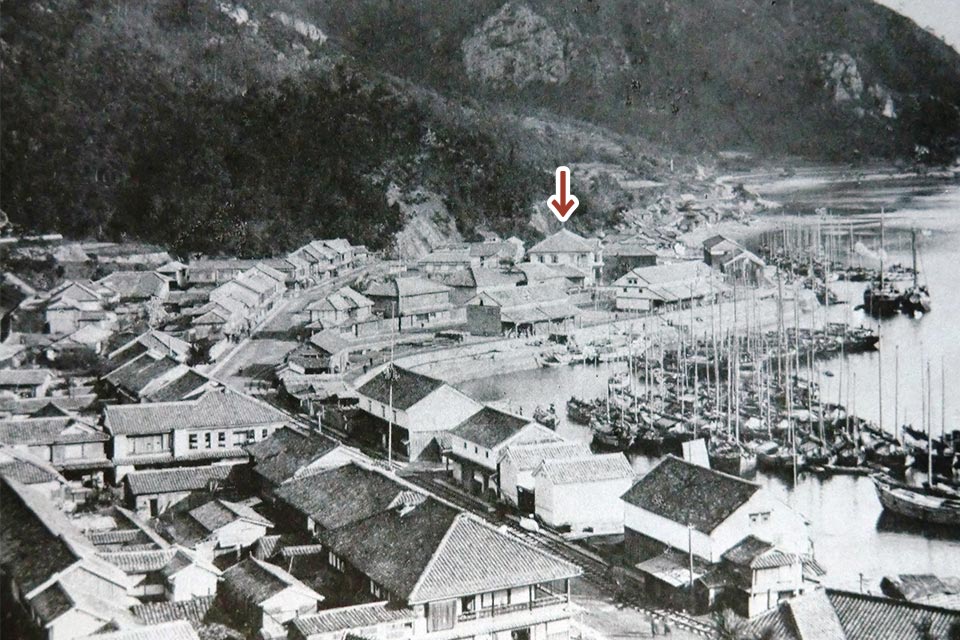 1887年~1905年ごろの三角西港の風景。下矢印で指している建物が「浦島屋」(写真は宇城市教育委員会提供、下矢印は編集部で付記)