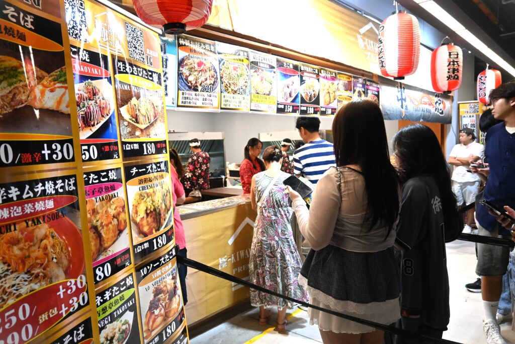 焼きそばやたこ焼きを販売する店には長蛇の列ができていました（ＮＮＡ撮影）