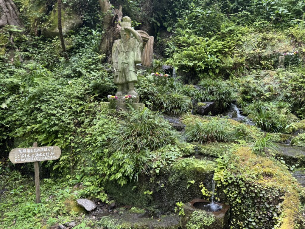 「お手水の御滝」を流れる複数の小さな滝と、加藤清正公像