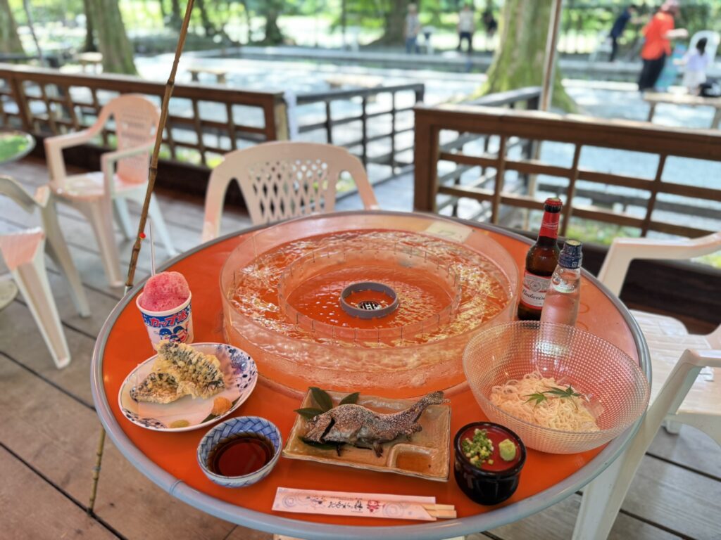 テーブルに並んだ、そうめん流し、ニジマスの塩焼きと天ぷら