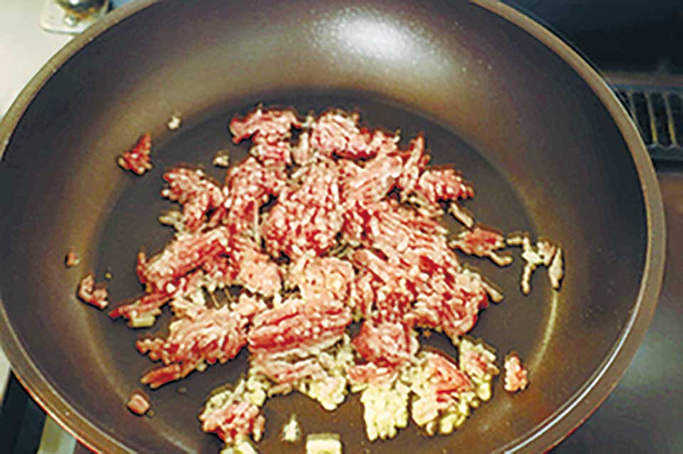 フライパンにごま油とニンニクを入れ、弱火にかける。香りが立ってきたら中火にして豚ひき肉を入れ、炒めずに焼き付ける。軽く焼き目が付いたらざっと炒め、塩をふる。