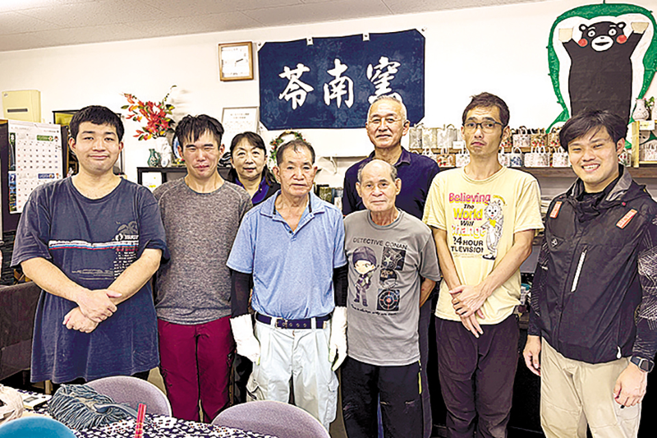 和気あいあいと作品づくりに打ち込む利用者とスタッフ。後列中央が田中祐介施設長