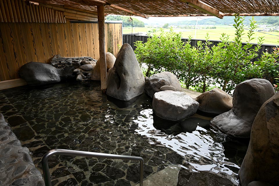 露天風呂は、景色を眺めながら半身浴もできるよう段差があり、内湯の高い天井と立派な梁(はり)も圧巻