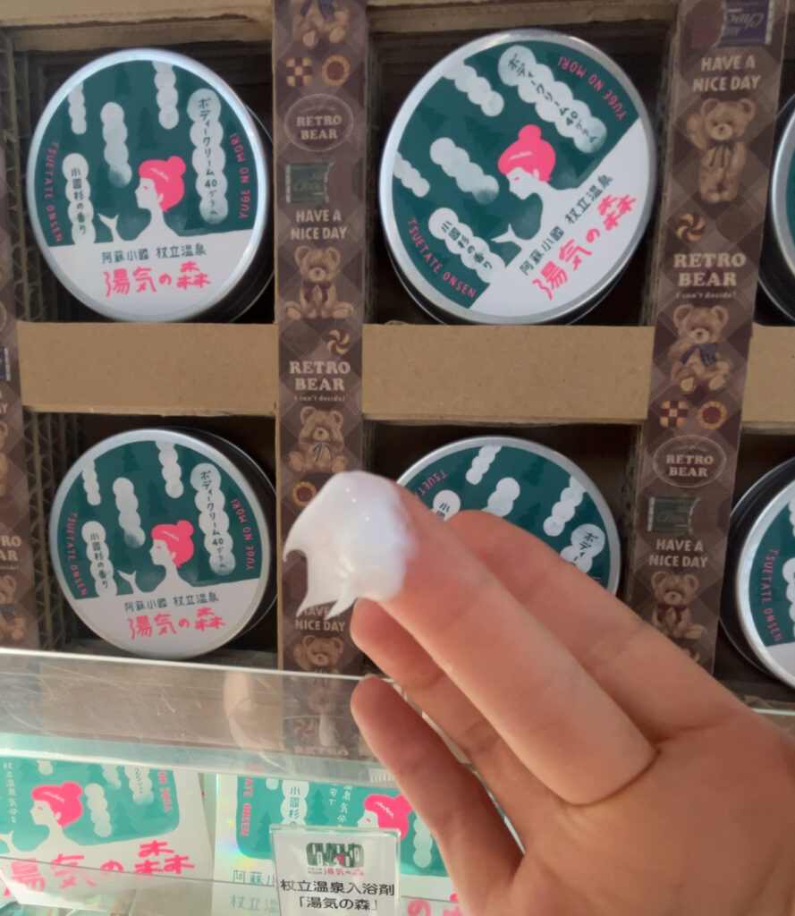 湯気の森温泉ボディクリームを指ですくっているところ