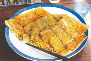 熊本を代表するB級グルメ「ちょぼ焼」350円~。肉、イカ、エビ、野菜、麺、卵全部を入れても900円。トッピングやスパイスで多彩な味わいを楽しんで