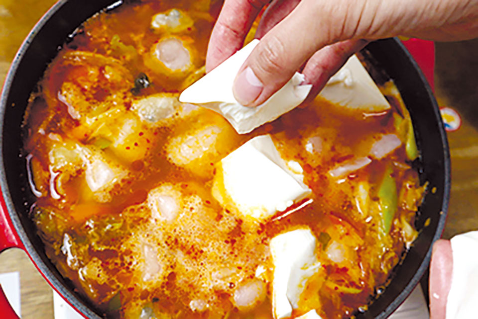 (4)が煮立ったら冷凍シーフードミックス、手で大きめにちぎった豆腐を入れて煮る。