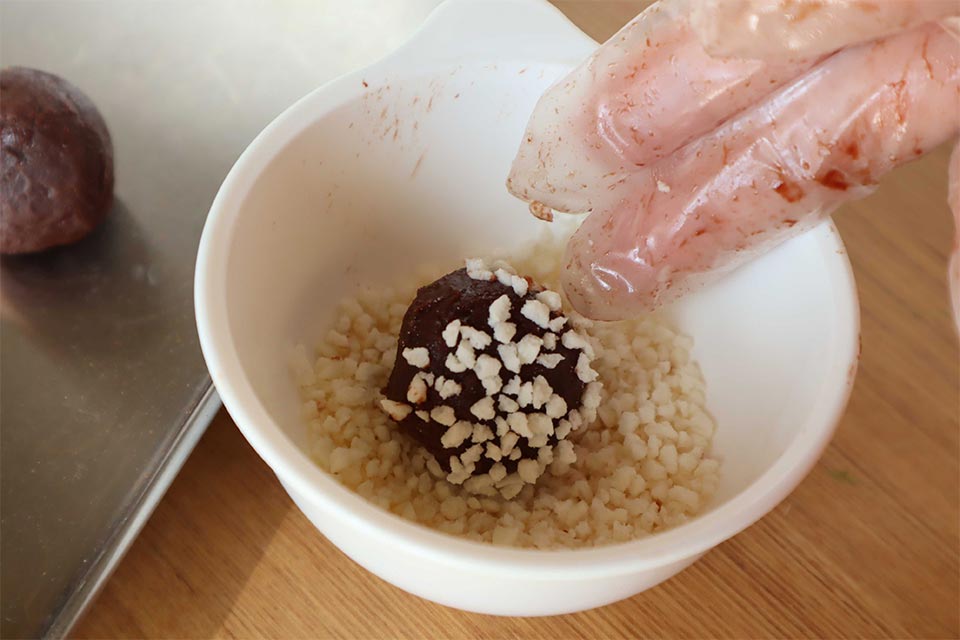 ラップまたはナイロン手袋などを使用し、(5)を丸める。手の熱で表面が少し溶けているうちに、お好みのコーティングをする。