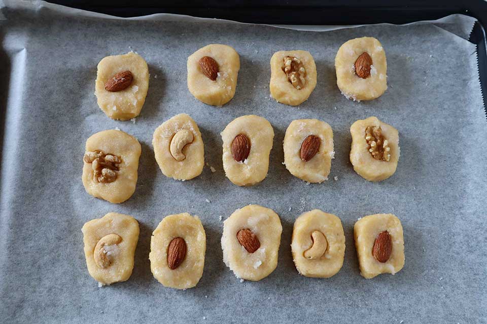 （7）の生地中央にナッツを押し込み、指で軽くクッキーの形を丸く整える。170℃に温めたオーブンで20分焼く。焼き色が足りないときは、続けて180℃で3～5分焼く。