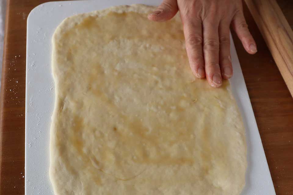 まな板に打ち粉をし、（2）の生地をのせ、18×25cm程度の四角形に延ばし、表面全体にごま油を塗る。
