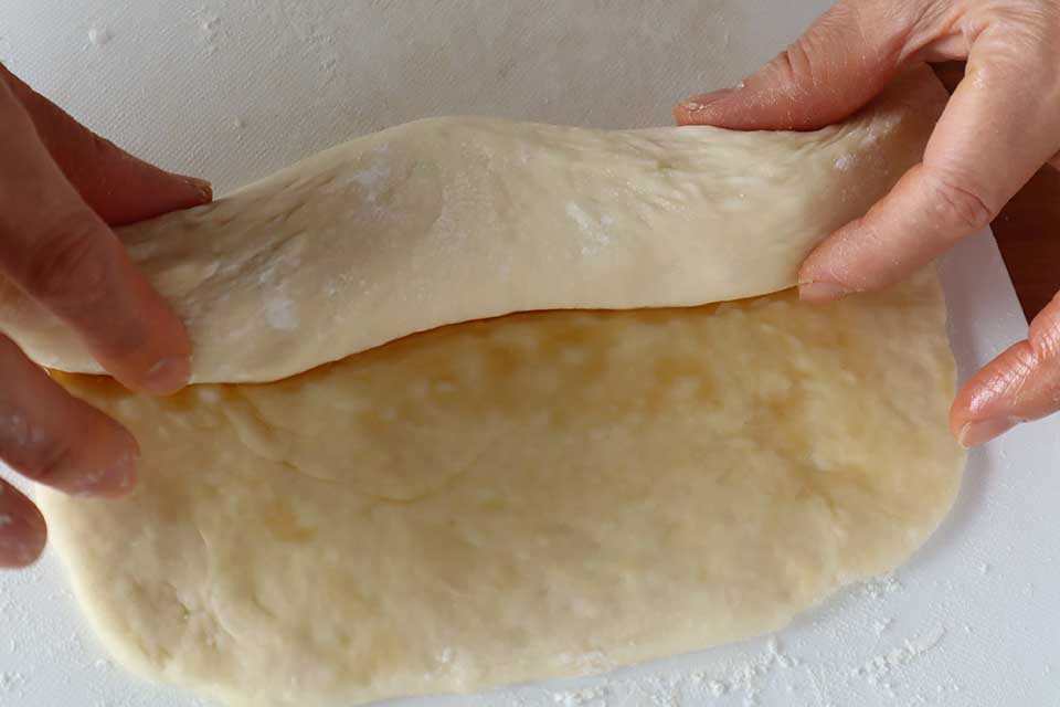 （3）を手前からくるくると巻いて棒状にする。