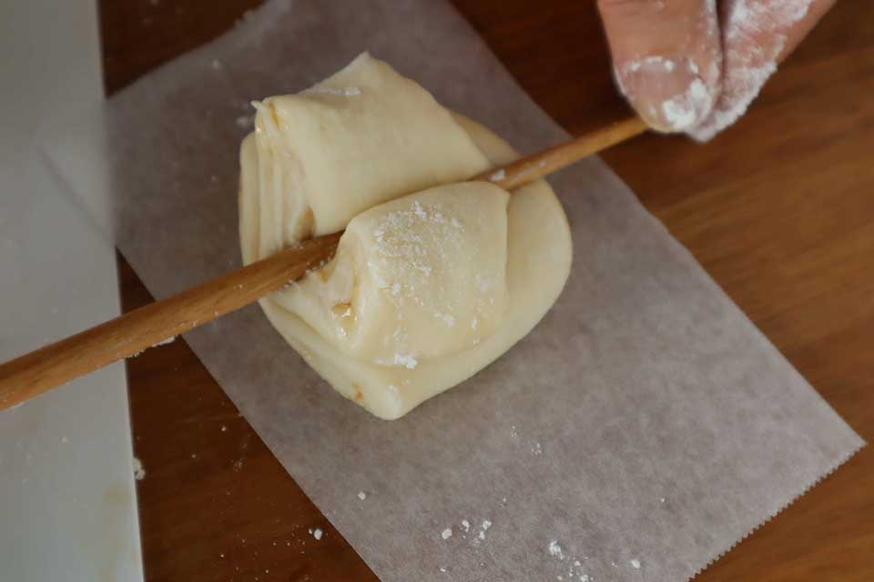 オーブンシートにカットした生地を2つ重ねてのせ、真ん中に箸をギュッと押し付け、ハートのような形にする。